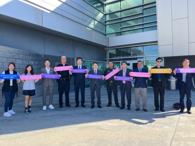 Members of the Korean American community pose for photos in front of the LAPD station in Koreatown, Los Angeles, on Oct. 22, as part of the 