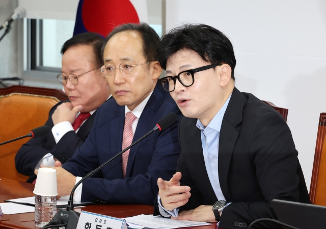 People Power Party leader Han Dong-hoon (right) speaks during a Supreme Council meeting at the National Assembly in Seoul on Thursday. (Yonhap)