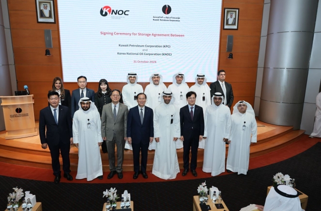 Kim Dong-sub, CEO of Korea National Oil Corp. (fourth from left, front row), KPC Chairman Shaikh Nawaf Saud Al-Sabah (fourth from right, front row), and South Korean Ambassador to Kuwait Park Jong-seok (third from left, front row) pose for a commemorative photo following a joint stockpiling signing ceremony at KPC's headquarters in Kuwait, Thursday. (KNOC)