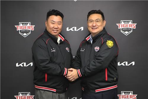 Kia Tigers manager Lee Bum-ho (left) shakes hands with his general manager Shim Jae-hak after signing a three-year extension with the Korea Baseball Organization club. (Yonhap)