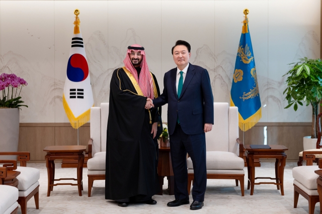 South Korean President Yoon Suk Yeol shakes hand with Abdullah bin Bandar Al Saud, Saudi minister of the National Guard, at the presidential office in Seoul on Tuesday. (Yonhap)