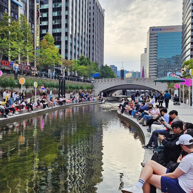 People read books at an outdoor library, which opened along the Cheonggye Stream. (Seoul Metropolitan Library)