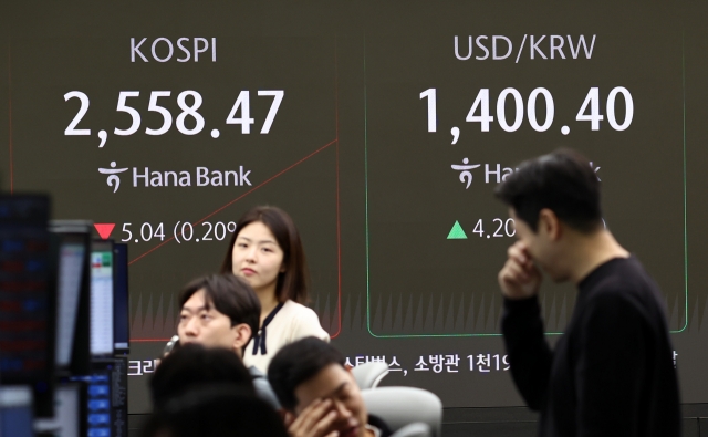 An electronic board in a dealing room at the Hana Bank headquarters in Seoul shows the Kospi standing at 2,558.47, down 5.04 points, or 0.2 percent, from the previous day, and the Korean won against the US dollar trading at 1,400.4 won, as the local currency loses 4.2 won during intraday trading hours Thursday. (Yonhap)