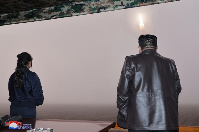 North Korean leader Kim Jong-un (right) and his daughter Kim Ju-ae observe the firing of the new Hwasong-19 intercontinental ballistic missile conducted on Oct. 31 in this photo carried by North Korea's state-run Korean Central News Agency the following day. (Yonhap)