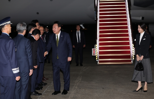 President Yoon Suk Yeol (center) and first lady Kim Keon Hee arrive at Seoul Air Base in Seongnam, just south of Seoul, Oct. 11, after a three-nation Southeast Asia trip. (Yonhap)