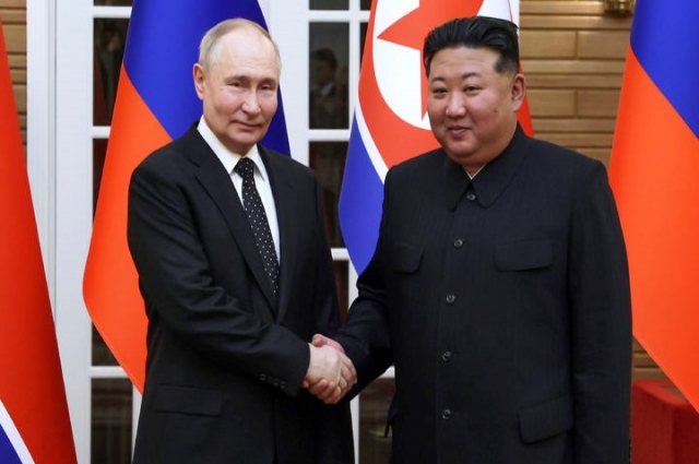 North Korean leader Kim Jong-un (right) shakes hands with Russian President Vladimir Putin after signing a comprehensive strategic partnership treaty, in this photo published by the Korean Central News Agency on June 20. (Newsis)