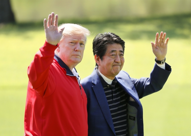 The then-US President Donald Trump and the late former Japanese Prime Minister Shinzo Abe wave on the way to play golf at Mobara Country Club on May 26, 2019 in Chiba, Japan. (Getty Images)