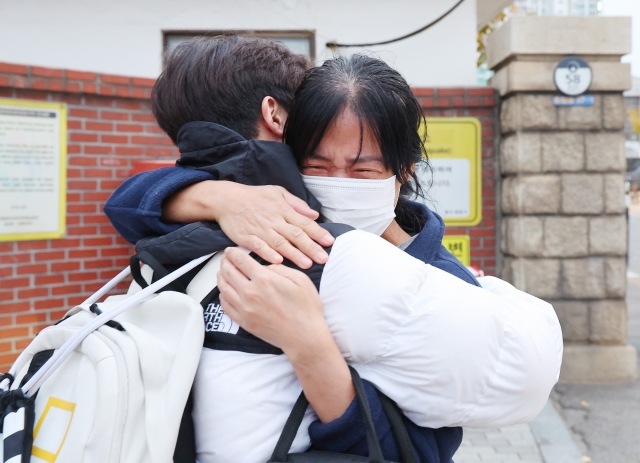 A parent encourages her child in front of the test center at Dongsan High School in Dong-gu, Incheon, on the morning of the 2025 Suneung held Thursday. (Yonhap)