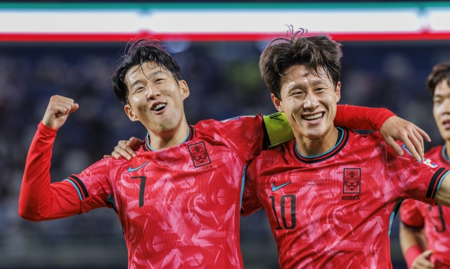 Son Heung-min of South Korea (left) celebrates with teammate Lee Jae-sung after scoring a penalty against Kuwait during the teams' Group B match in the third round of the Asian World Cup qualification at Jaber Al-Ahmad International Stadium in Kuwait City on Nov. 14, Thursday. (Yonhap)