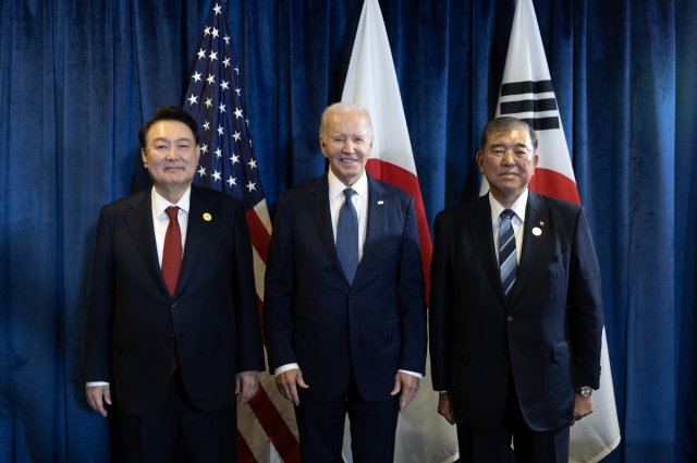 (From left) South Korean President Yoon Suk Yeol, US President Joe Biden, and Japanese Prime Minister Shigeru Ishiba pose for a photo on the sidelines of the Asia-Pacific Economic Cooperation meeting in Lima on Friday. (Yonhap)