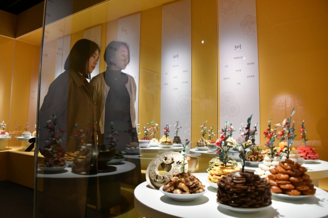 Visitors look at items on display the exhibition “Joseon’s Royal Cuisine: A Table for Food, Reverence and Sharing” at the National Palace Museum of Korea in Seoul on Tuesday. (NPMK)