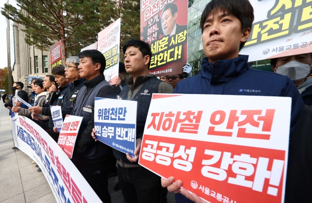 Unionized workers of Seoul Metro, which operates subway Line Nos. 1 through 8, hold placards calling for better working conditions as they take part in a press conference in front of the City Hall in central Seoul on Tuesday. (Yonhap)