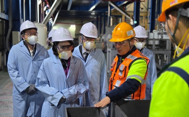 Second Vice Foreign Minster Kang In-sun (second from left) speaks with an official from Posco Future M at the company’s anode materials manufacturing in Sejong on Monday. (Posco Future M)