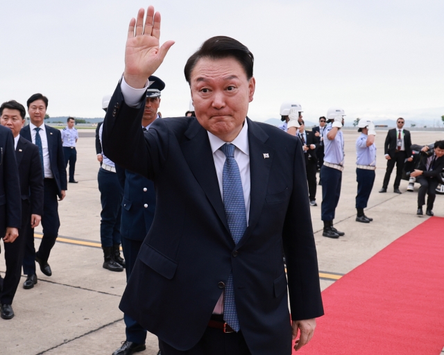 President Yoon Suk Yeol waves as he embarks on his flight back to South Korea at Galeao Air Force Base in Rio de Janeiro, Brazil, Tuesday. (Yonhap)