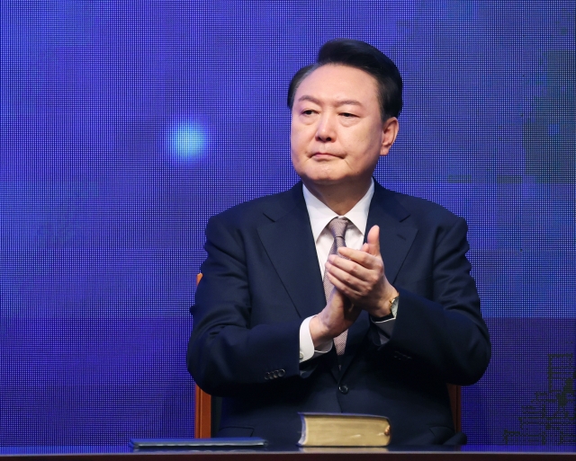 President Yoon Suk Yeol claps his hands a national prayer breakfast in Seoul on Friday. (Pool photo via Yonhap)