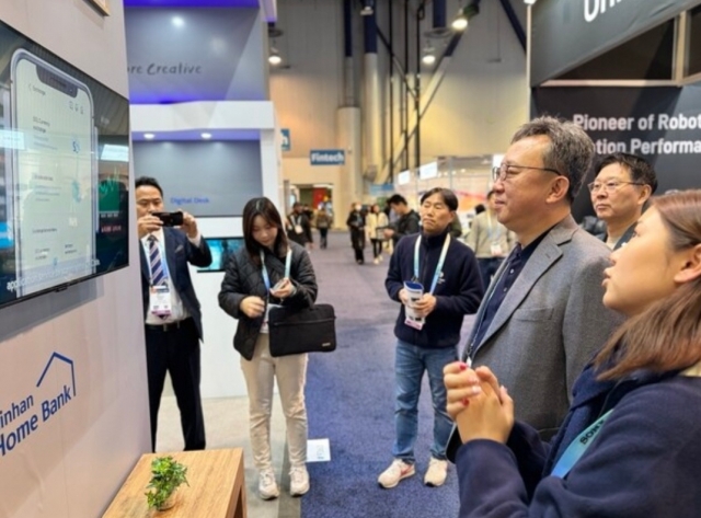 Shinhan Bank CEO Jung Sang-hyuk views the bank's AI technologies on display at CES 2024, held Jan. 9-12 in Las Vegas. (Shinhan Bank)