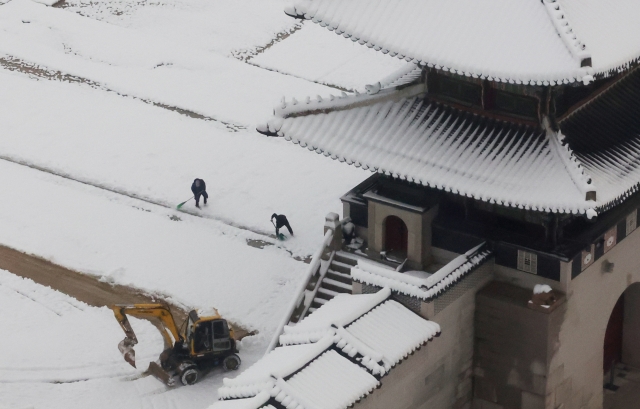 Snow removal processes are taking place in Gyeongbokgung, central Seoul, Thursday, as snowfall of up to 27.8 centimeters was recorded in the capital. (Yonhap)