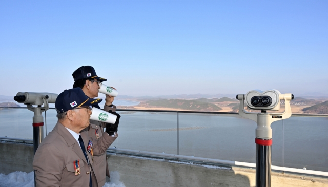 Vietnam War veterans sip Starbucks coffee while gazing at the other side of the Korean Peninsula in Gimpo on Friday. (Im Se-jun/The Korea Herald)