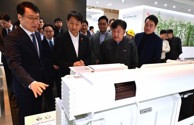 Industry Minister Ahn Duk-geun (second from left) is briefed on a chiller model by Lee Jae-sung (far left), head of eco solution business at LG Electronics, at the company's plant in Pyeongtaek, Gyeonggi Province, on Monday. (LG Electronics)