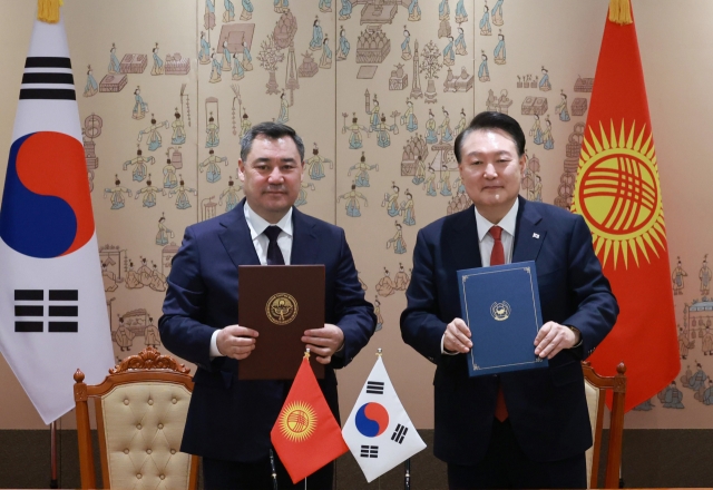 President Yoon Suk Yeol (right) and Kyrgyz President Sadyr Japarov are seen during the signing ceremony of the Comprehensive Partnership of South Korea and Kyrgyzstan on the occasion of the summit held at the presidential office in Seoul, Tuesday. (Yonhap)