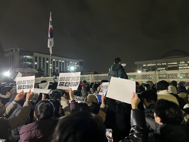 Citizens hold signs reading 