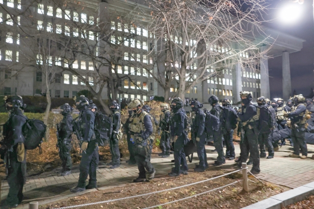 Armed forces are seen retreating from the Assembly building. (Yonhap)