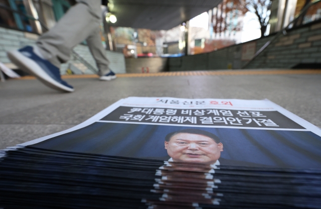 A special edition extra newspaper covering President Yoon Suk Yeol's public address and announcement lifting martial law is displayed near Jonggak Station in central Seoul on Wednesday morning. (Yonhap)