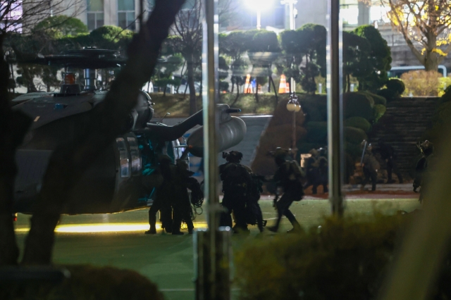 Soldiers deployed to the National Assembly in Seoul get off a helicopter in the early hours of Wednesday. (Yonhap)