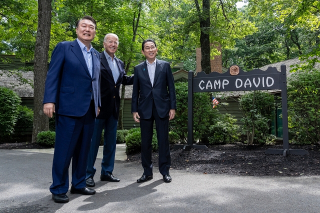 President Joe Biden poses for an official photo with Japanese Prime Minister Fumio Kishida and President of the Republic of Korea Yoon Suk Yeol before their trilateral meeting on August 18, 2023, at Laurel Cabin at Camp David, Maryland. (White House)