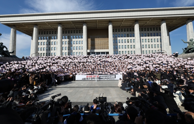 Opposition lawmakers, including Democratic Party leader Lee Jae-myung and Rebuilding Korea Party leader Cho Kuk, chant slogans during an emergency rally at the National Assembly in Yeouido, Seoul, on Wednesday, urging President Yoon Suk Yeol to resign and face impeachment. (Yonhap)