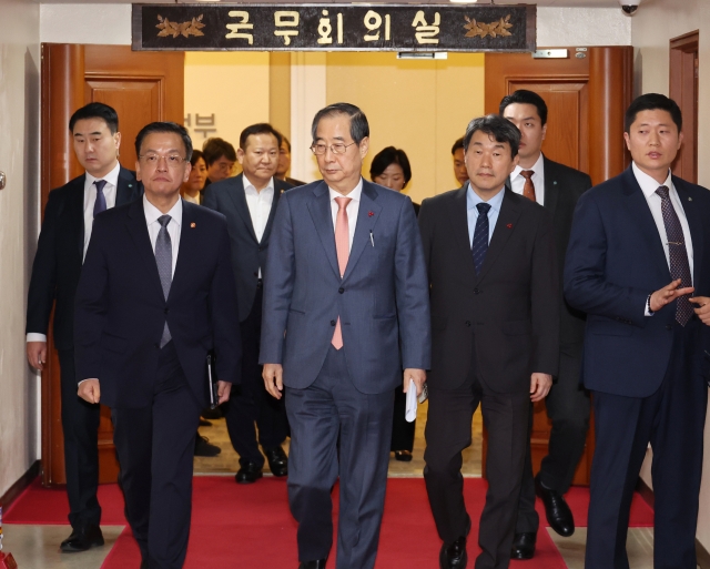 Prime Minister Han Duck-soo (second from left) and Finance Minister Choi Sang-mok (left) and other Cabinet members leave a conference room after their meeting at the government complex in Seoul on Wednesday. (Yonhap)