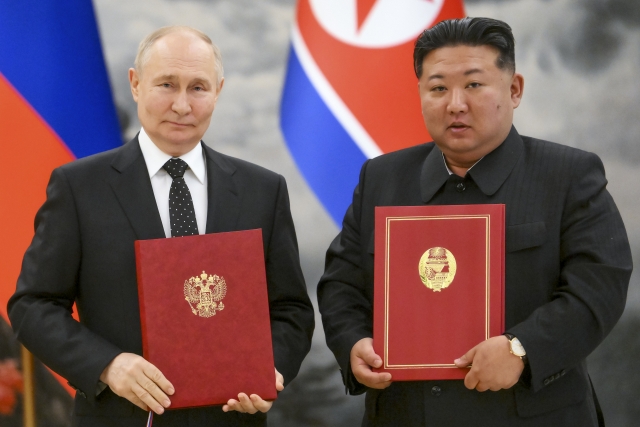 Russian President Vladimir Putin (left) and North Korea's leader Kim Jong-un pose for a photo during a signing ceremony of the new partnership in Pyongyang, on June 19. (AP-Yonhap)