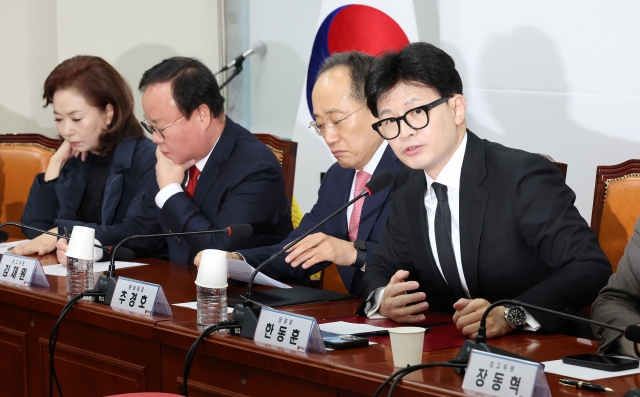 Han Dong-hoo (right) speaks during the ruling People Power Party's Supreme Council meeting at the National Assembly on Thursday. (Yonhap)