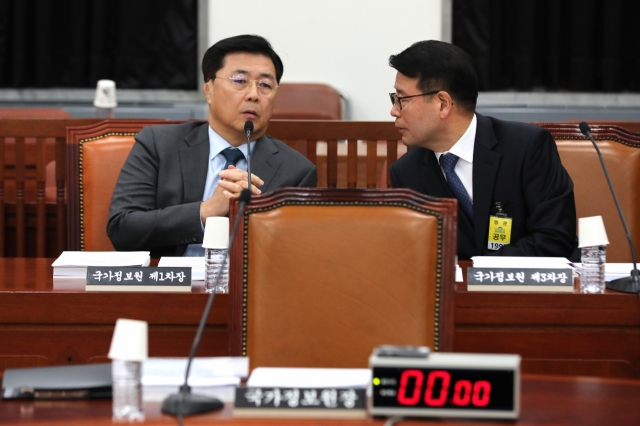 Hong Jang-won (left), the first deputy director of the National Intelligence Service, is seen speaking with the NIS third deputy director, Yoon Oh-jun, at the National Assembly on Nov. 20. (Yonhap)