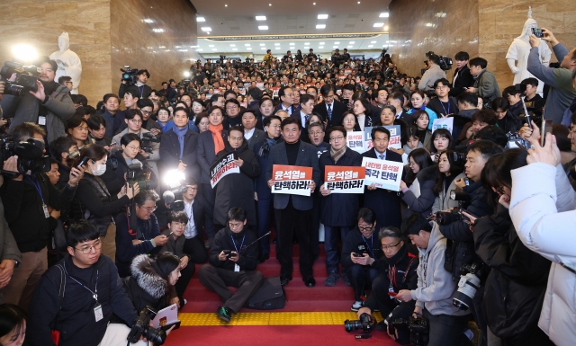 Opposition lawmakers hold signs saying 