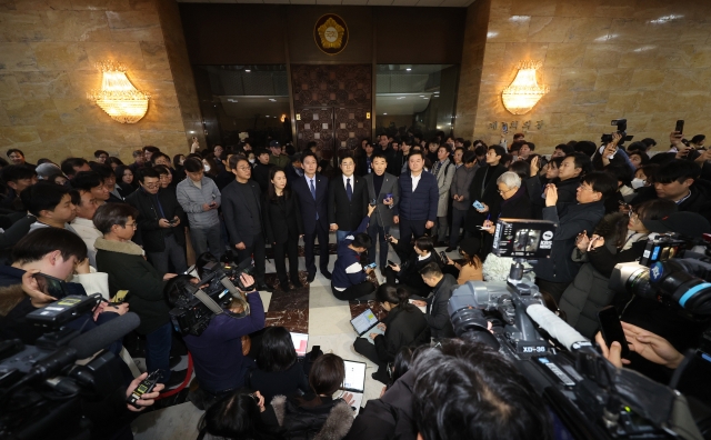 Members of the main opposition Democratic Party announce their stance at the National Assembly in Seoul in the early hours of Wednesday, shortly after an emergency plenary session passed a resolution urging the president to withdraw a martial law order. (Yonhap)