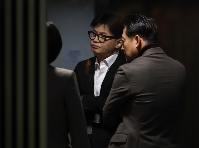 People Power Party leader Han Dong-hoon is seen engaged in conversations with lawmakers after stepping out of the general assembly meeting held at the National Assembly in Yeouido, Seoul, Friday. (Yonhap)