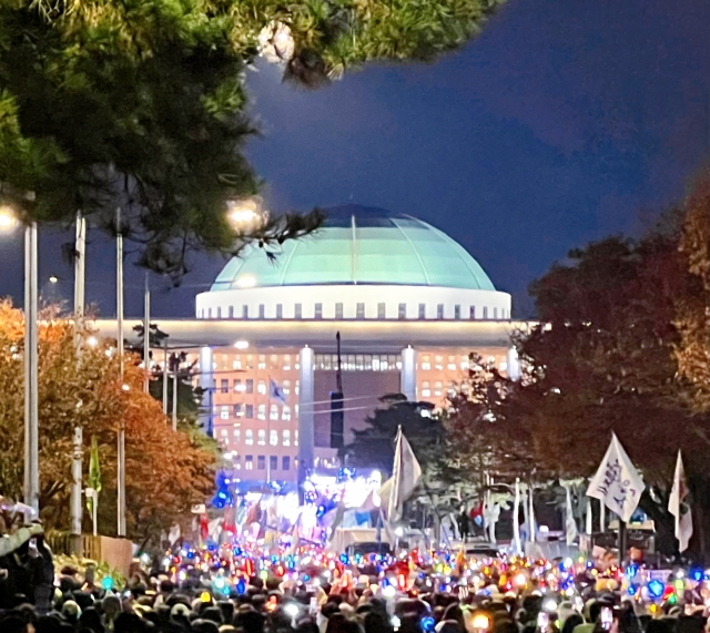 Protesters gather in front of the National Assembly building in Yeouido, Seoul, on Saturday. (Park Yuna/The Korea Herald)