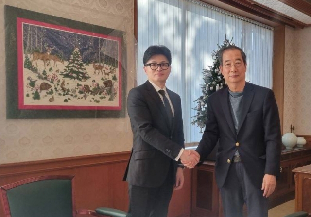 Prime Minister Han Duck-soo, left, shakes hands with People Power Party Chair Han Dong-hoon during their meeting at the prime minister's residence in Seoul on Saturday. Yonhap