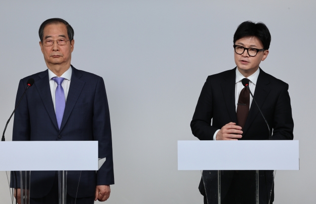 Prime Minister Han Duck-soo (left) and ruling People Power Party leader Han Dong-hoon deliver a joint public address at the PPP headquarters in Seoul on Sunday, one day after the parliamentary vote to impeach President Yoon Suk Yeol for his martial law imposition failed. (Yonhap)