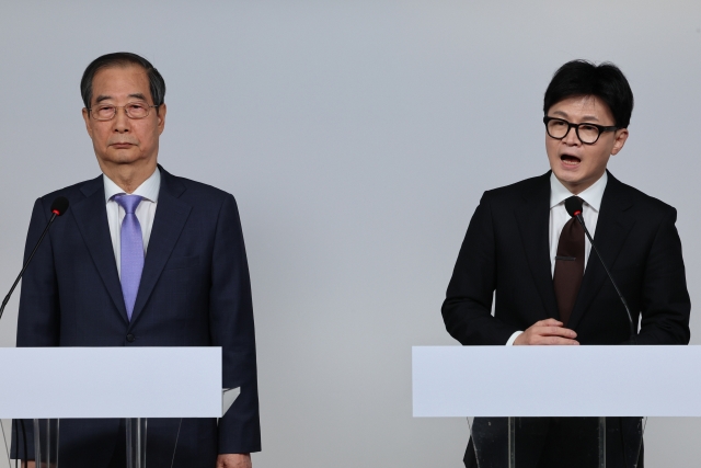 Prime Minister Han Duck-soo (left) and ruling People Power Party (PPP) leader Han Dong-hoon deliver a joint public address at the PPP headquarters in Seoul on Sunday. (Yonhap)