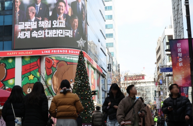 A video featuring President Yoon Suk Yeol plays at a building in Myeong-dong, a popular tourist destination in Seoul, Thursday. (Yonhap)