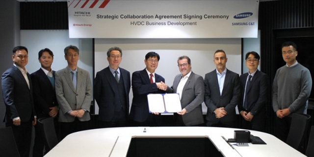 Samsung C&T Executive Vice President Kim Sung-joon (center left) shakes hand with Armand Pineda (center right), senior vice president at the marketing and sales division of Hitach Energy, and other company officials pose at the partnership signing ceremony in Seoul. (Samsung C&T)