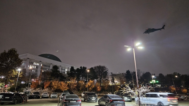 A military helicopter hovers over the National Assembly following a martial rule decree on Tuesday night in Seoul. (Yonhap)