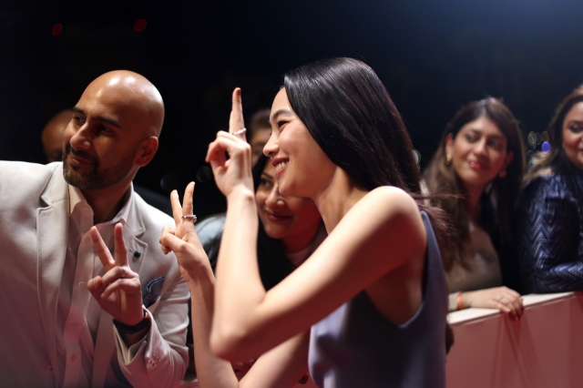 Jung Ho-yeon poses for a photo with an audience member during the Red Sea International Film Festival red carpet event in Jeddah, Saudi Arabia on Dec. 7. (RSIFF)