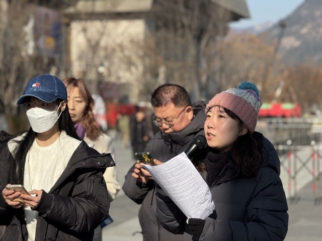 Nanda (right) , an 18-year-old activist with Jieum, speaks at Gwanghwamun Square in Seoul on Tuesday, addressing a crowd of youth activists demanding President Yoon Seok Yeol’s resignation over martial law and human rights concerns. (Moon Joon Hyun/The Korea Herald)