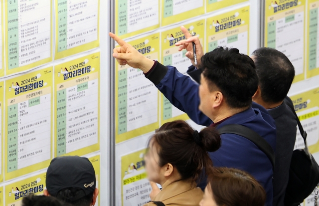 This Nov. 26, file photo shows jobseekers checking job postings at an employment center in Incheon. (Yonhap)