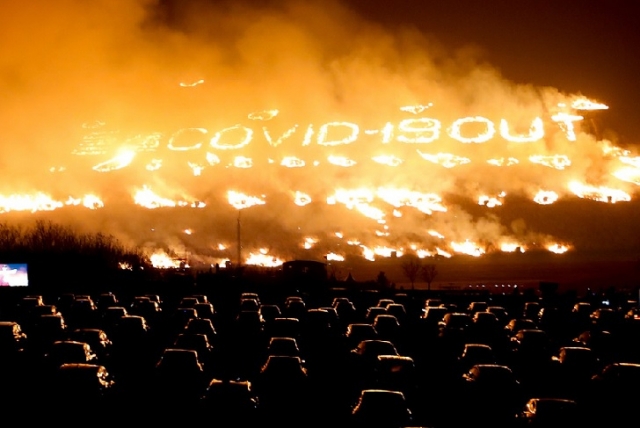 People in cars watch a grass field burn as part of the Jeju Fire Festival held in March 2021 (Jeju provincial government)