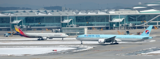 Korean Air and Asiana Airlines planes are parked side by side at Incheon Airport on Nov. 29. (Newsis)