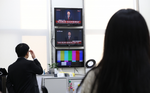 Officials of the main opposition Democratic Party of Korea watch President Yoon Suk Yeol's public address on Dec. 7 at the National Assembly in Seoul. (Yonhap)